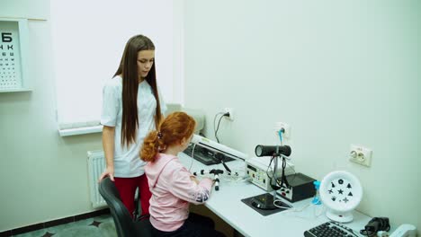 girl patient at doctor ophthalmologist. young girl checking his eyesight on special medical equipment