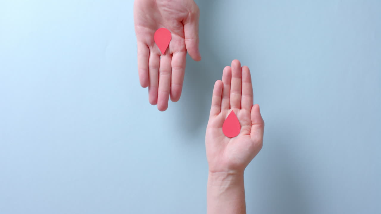 카우카시안 사람들의 손은 파란색 배경에 혈액 방울을  ⁇ 고 복사 공간, 느린 동작