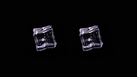 pair of identical ice cubes spinning in space with black background, static studio shot