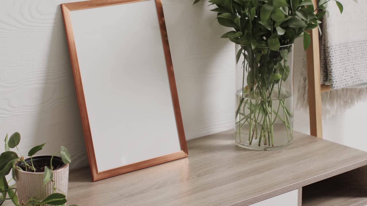 marco de madera con espacio de copia en fondo blanco con plantas en el escritorio contra la pared blanca