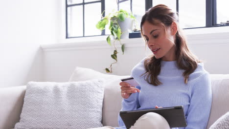 at home, woman reading card and using tablet, enjoying cozy holiday moment, copy space