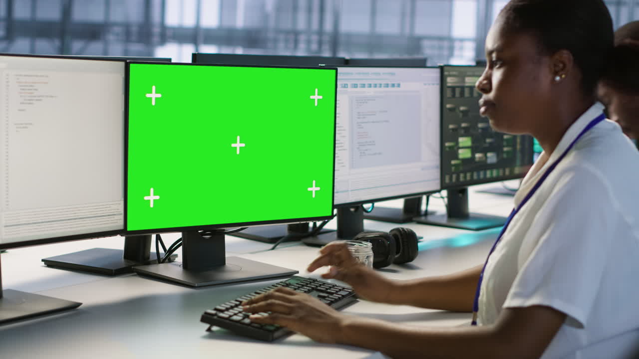 mujer trabajando en computadoras en una sala de control