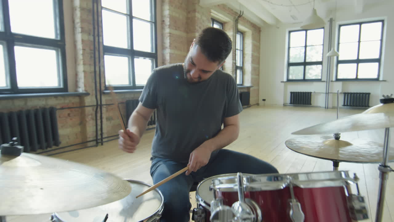 Professional Male Drummer Playing Drumkit