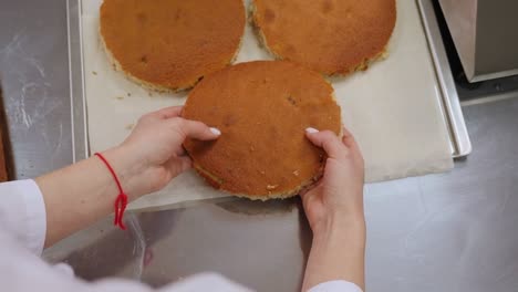 close-up of the cook laying out a biscuit dough on a baking sheet, making a cake