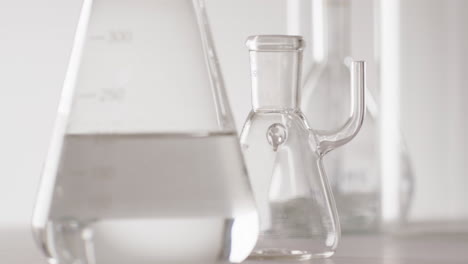 video of close up of glass laboratory beakers and dishes with copy space on white background