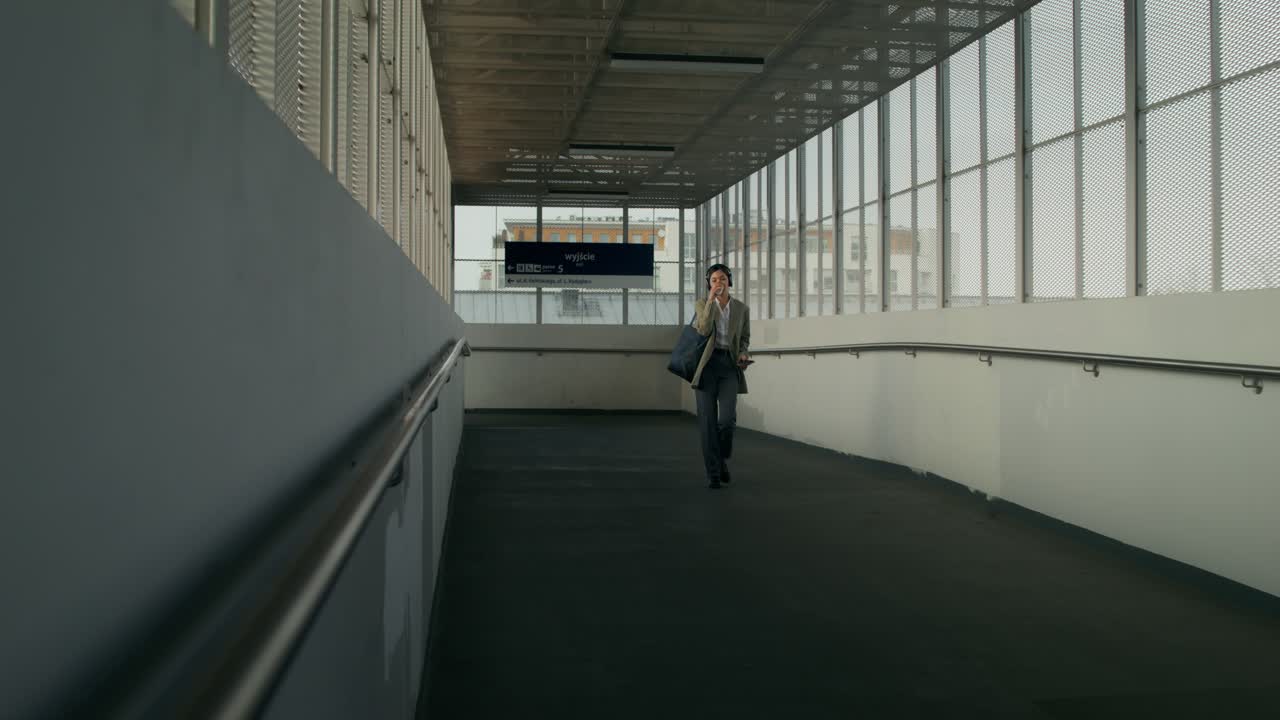 mujer de negocios caminando por una pasarela peatonal de un aeropuerto o estación de tren
