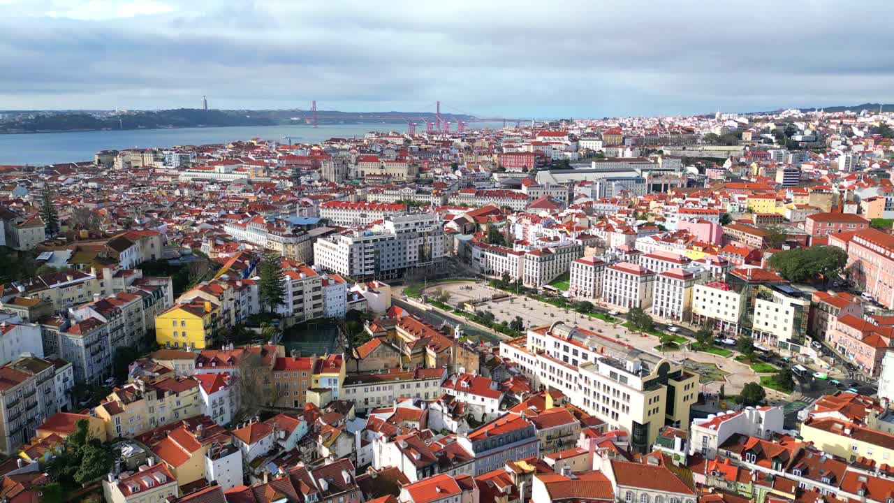 Volando sopra la città di Lisbona, concentrandosi su Piazza Martim Moniz, il luogo più multiculturale di Lisbona, che funge da punto d'incontro.