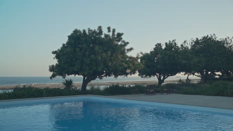 Still-shot-of-ripples-in-water-of-swimming-pool-overlooking-the-beach-ocean