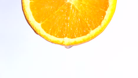 water or oils dropping on an orange slice , fruit for diet and healthy food