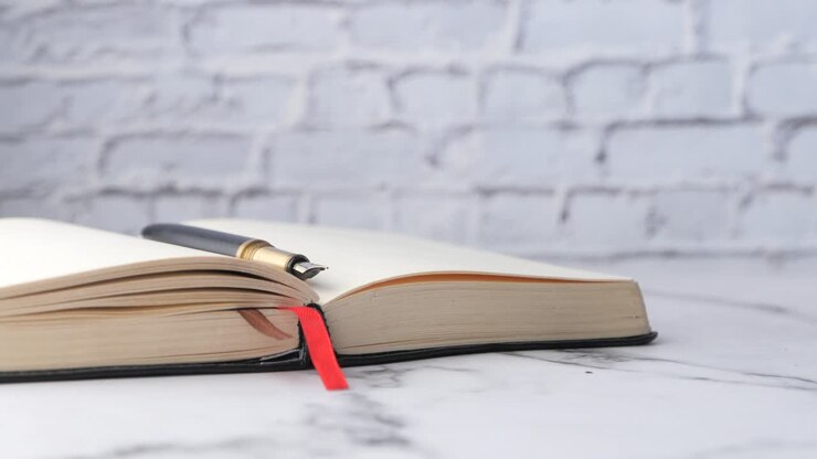 Libro aperto con penna e segnalibro su un tavolo di marmo