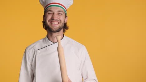 caucasian chef in front of camera on yellow background.