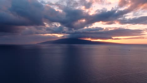 vistas aéreas de la sangrante puesta de sol naranja detrás de la isla lanai con veleros