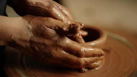 Woman-hands-sculpting-clay-product-in-workshop