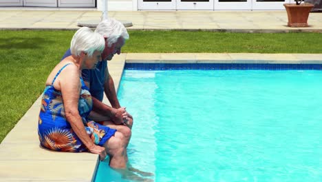 senior couple interacting with each other at poolside