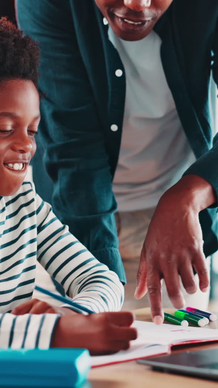 Padre afroamericano che aiuta il figlio con i compiti