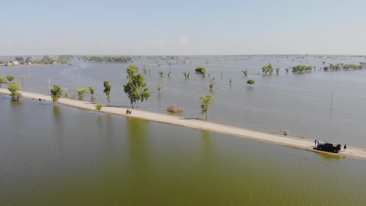 vista aérea de una carretera solitaria rodeada de aguas inundadas en el horizonte en jacobabad, sindh