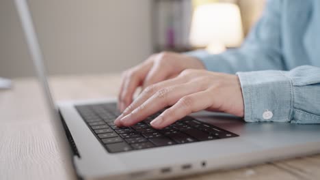 fotografía de cerca de las manos de una mujer de negocios escribiendo en el teclado de una computadora portátil para buscar información, soporte de comunicación en línea, investigación de mercadotecnia, informe de negocios en el escritorio de la oficina por la noche.
