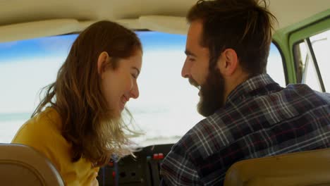 Happy-young-couple-interacting-with-each-other-in-van-4k