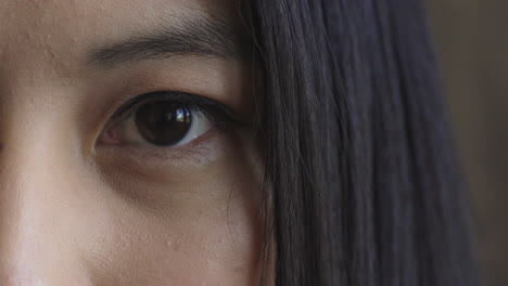 close up of young asian woman eye blinking looking at camera