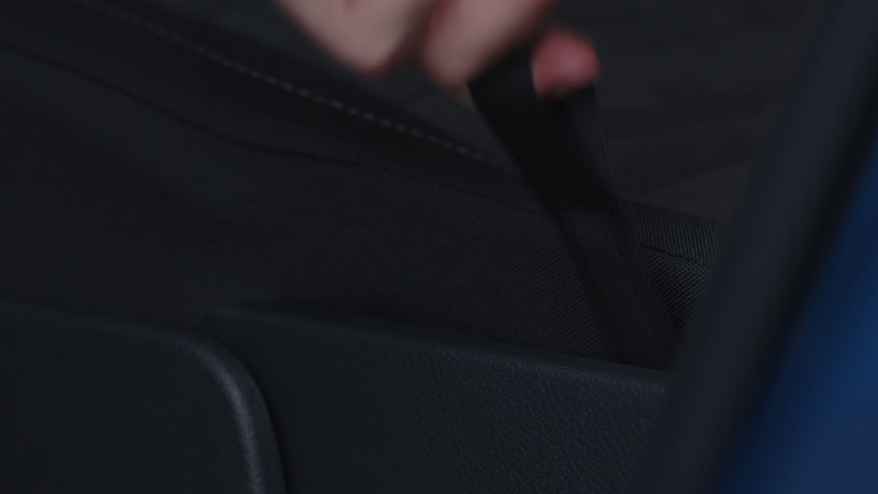 primer plano de tirar de la pestaña para plegar los asientos traseros de un coche