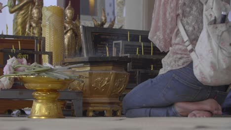 woman kneeling at buddhist shrine