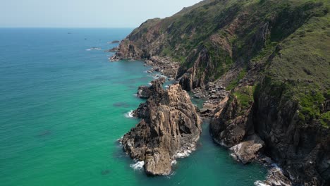 stunning slow motion rotating drone shot over stone cliffs next to ocean