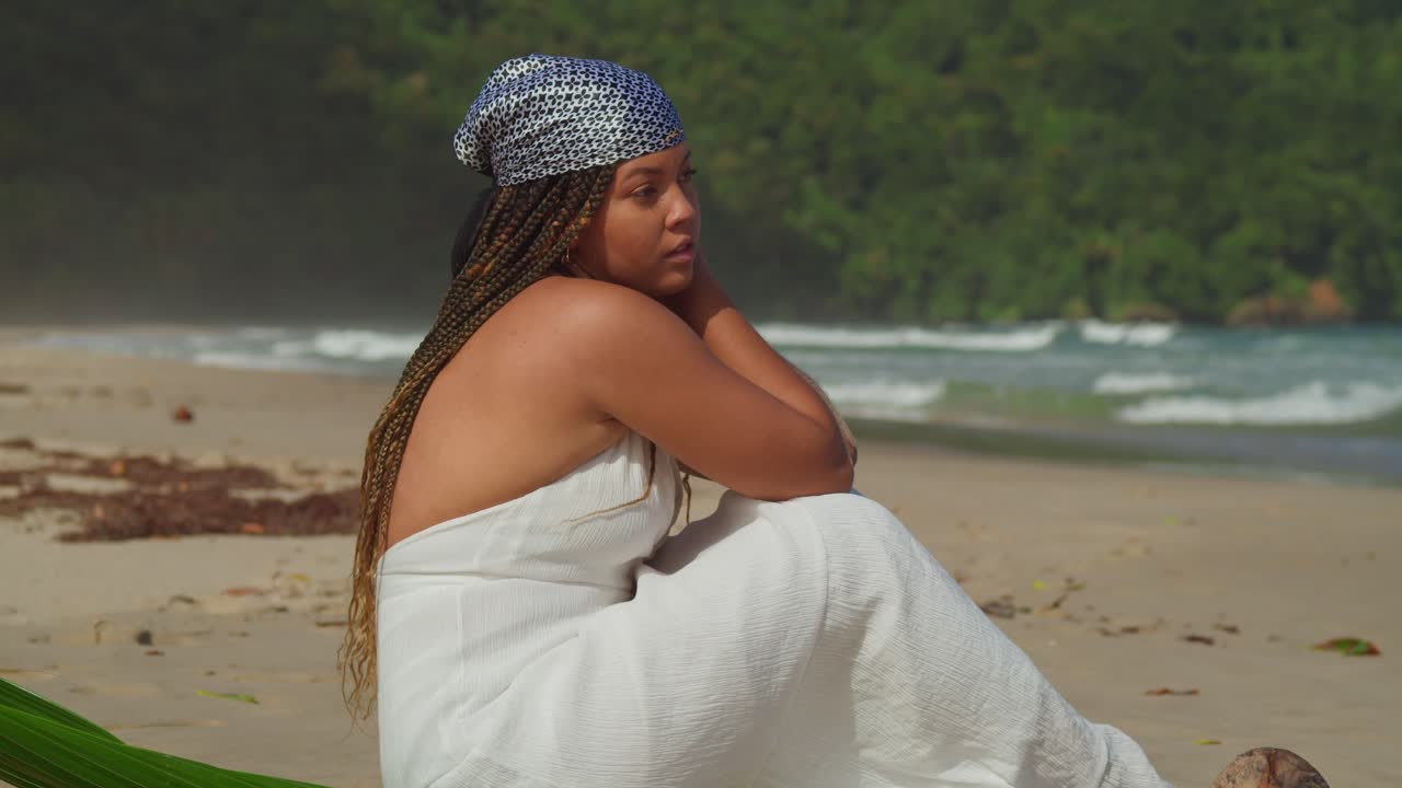 ampliar la cámara cerca de una mujer sentada en la playa en un día soleado en una isla tropical