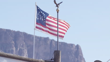 Die-Flagge-Der-Vereinigten-Staaten-Flattert-In-Zeitlupe-Vor-Den-Westlichen-Bergen