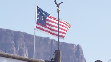 united states flag in slow motion flapping in front of western mountains