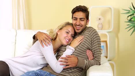 una linda pareja feliz descansando juntos en el sofá