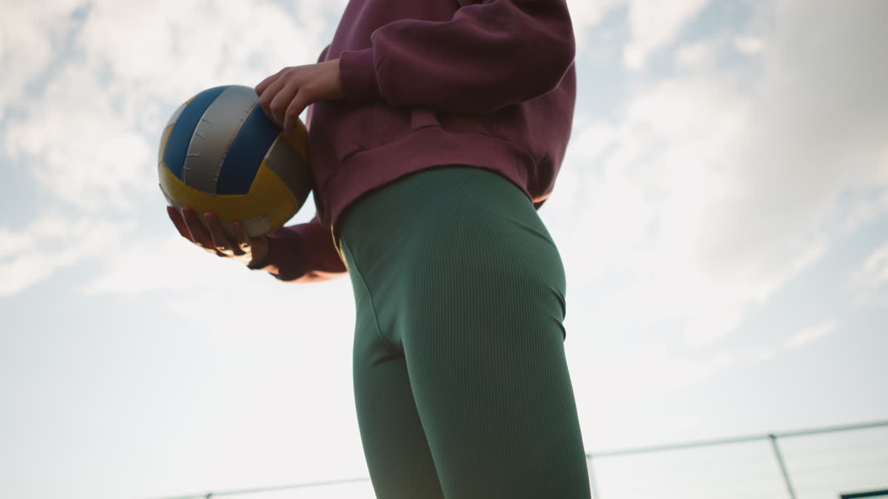 배구 연습 도중 놀이를 준비하는 운동 선수가 뜨거운 빛으로 카메라를 바라보며 발 주위에 황금빛을 만들고 있습니다.