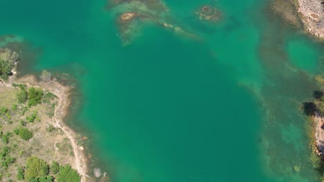 Overhead-aerial-view-of-beautiful-natural-lake-with-birds-flying,-Montpellier