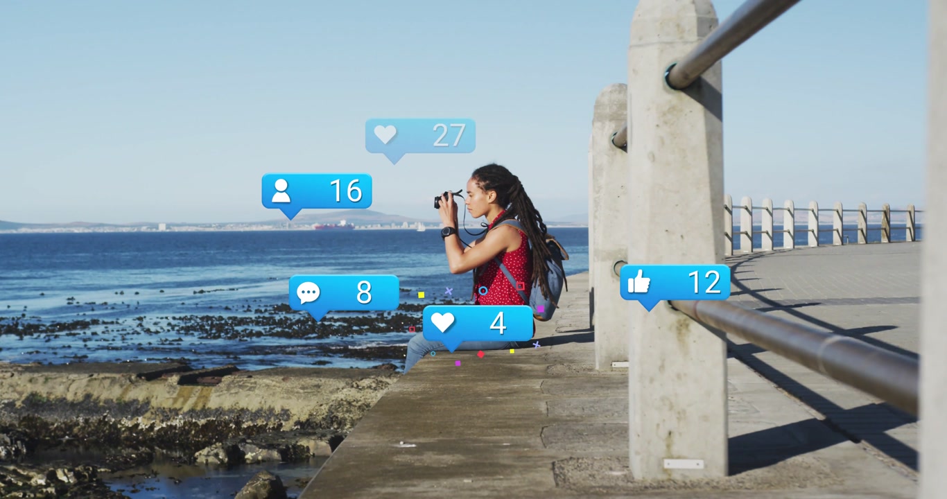 Shooting woman on pier, wearing red top, with camera and backpack, floating blue notifications