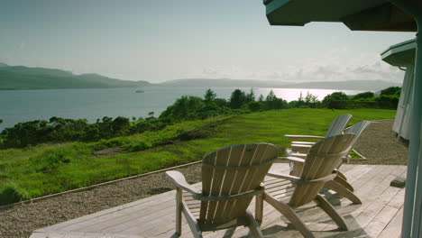 SLIDER-TRACKING-shot-of-deck-chairs-facing-the-Sound-of-Mull,-Scotland