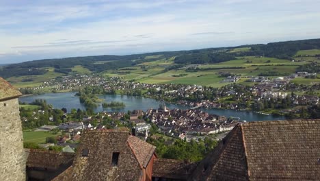 aerial dolly in of hohenklingen castle revealing stein am rhein picturesque village and rhine river in green valley, switzerland