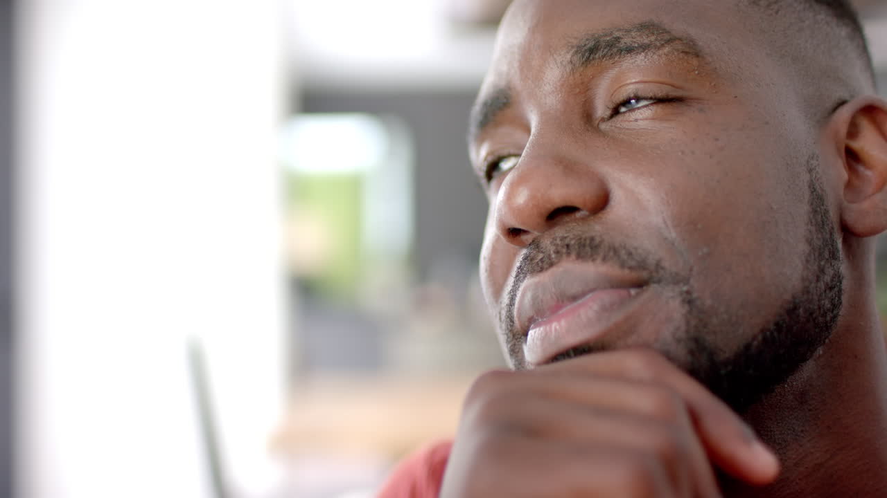 Close-up of an African American man with a thoughtful expression, indoors, at home, with copy space