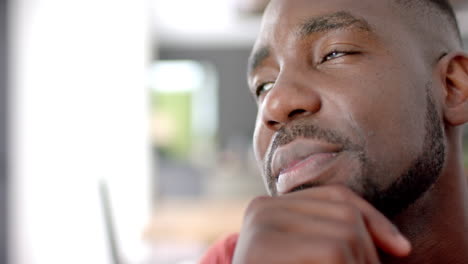 close-up of an african american man with a thoughtful expression, indoors, at home, with copy space