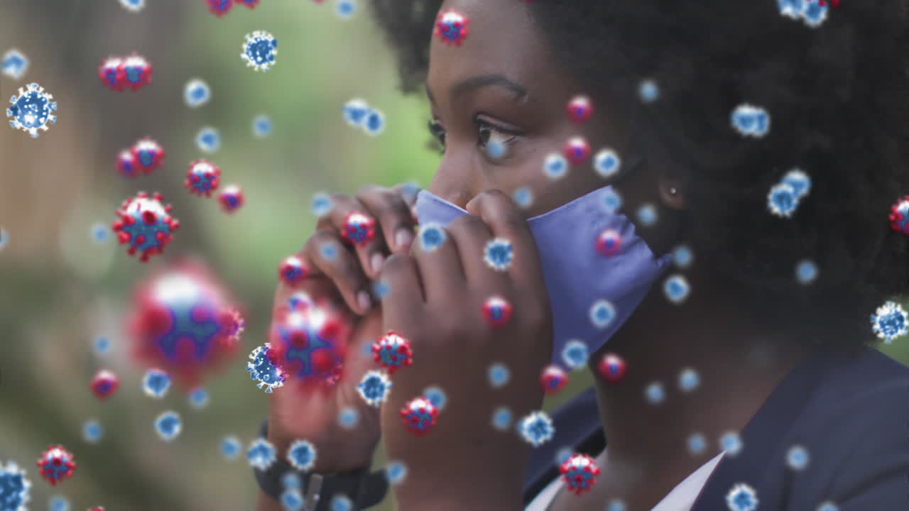 Animation of covid 19 cells over african american woman wearing face mask