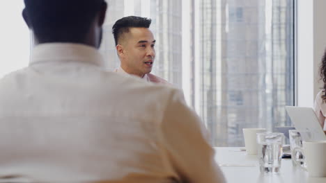 group of business professionals meeting around table in modern office