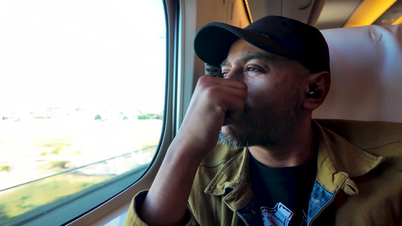 un hombre del sur de asia reflexiona mirando por la ventana de un tren, disfrutando de una experiencia de viaje. ilustra temas de viaje, contemplación y exploración personal
