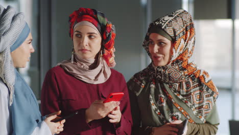 Businesswomen-in-Hijabs-Using-Smartphone-and-Speaking