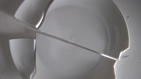 layed out pile of broken white plates rotating the camera around