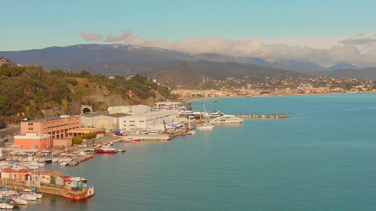 Yumuşak gün ışığı altında sakin bir sahil şeridi boyunca tekne ve yatlarla dolu marina, yamaç görünümü.