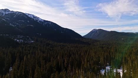 Scenic-view-above-evergreen-forest-and-snow-with-mountain-range-in-the-background-in-Cle-Elum-during-dusk-in-Washington-State