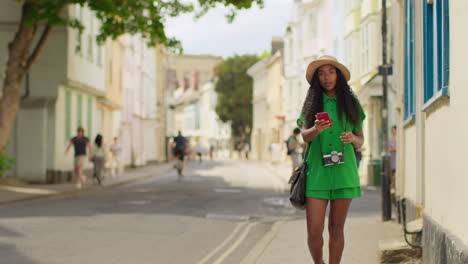 Turista-Femenina-Con-Cámara-De-Vacaciones-En-Oxford,-Reino-Unido,-Explorando-La-Ciudad-Caminando-Por-Holywell-Street-Usando-Un-Teléfono-Móvil-Para-Obtener-Direcciones-E-Información-4