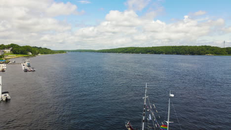 slow gentle pullback drone shot over the kennebec river showing a large sailing boat