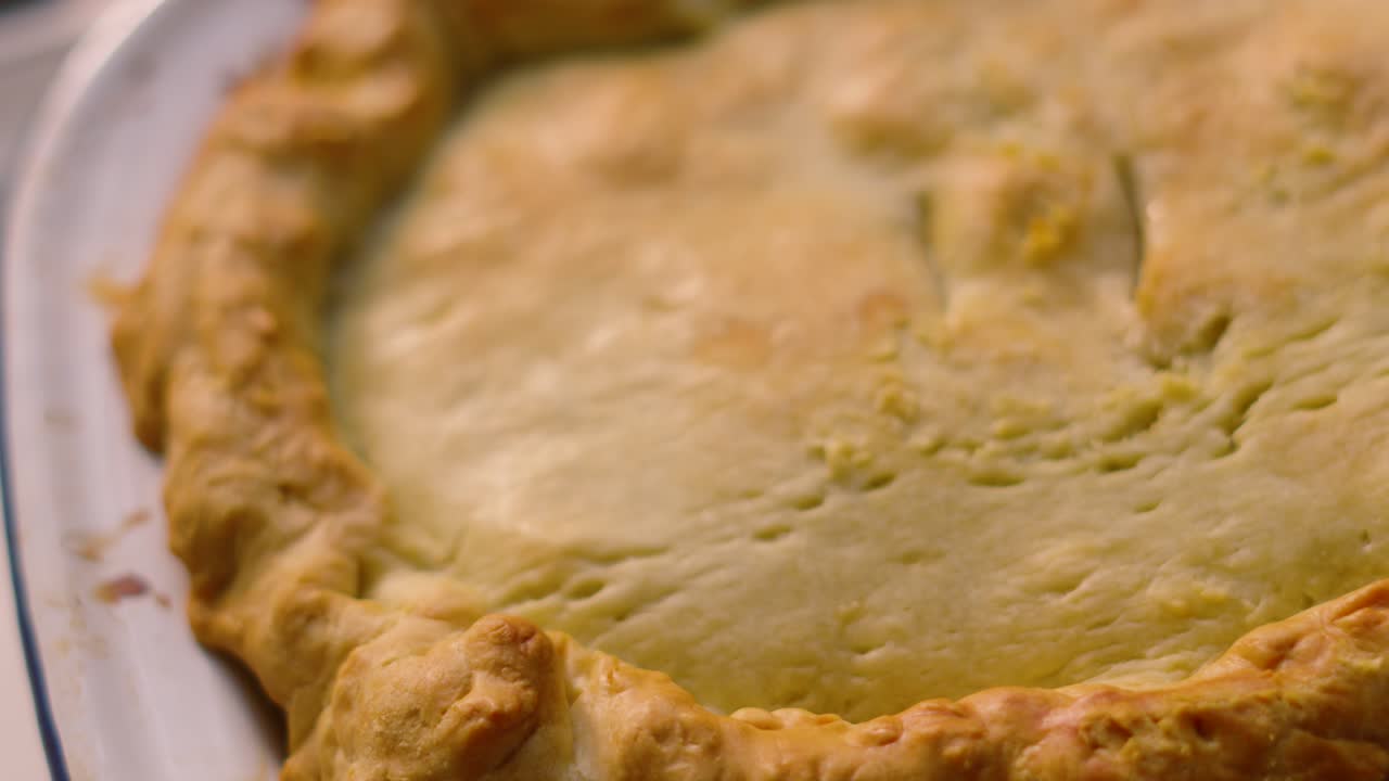 Moving Top Down View of Homemade Deep Filled Shortcrust Chicken Mushroom Vegetable Pie with Golden Crimped Pastry Ready to Eat. Comforting British Tasty Delicious Food.