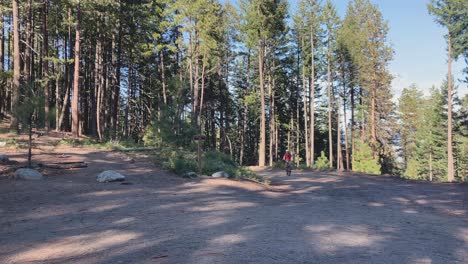 caucasian man riding a mountain bike up a slope on a curve in ashland, oregon