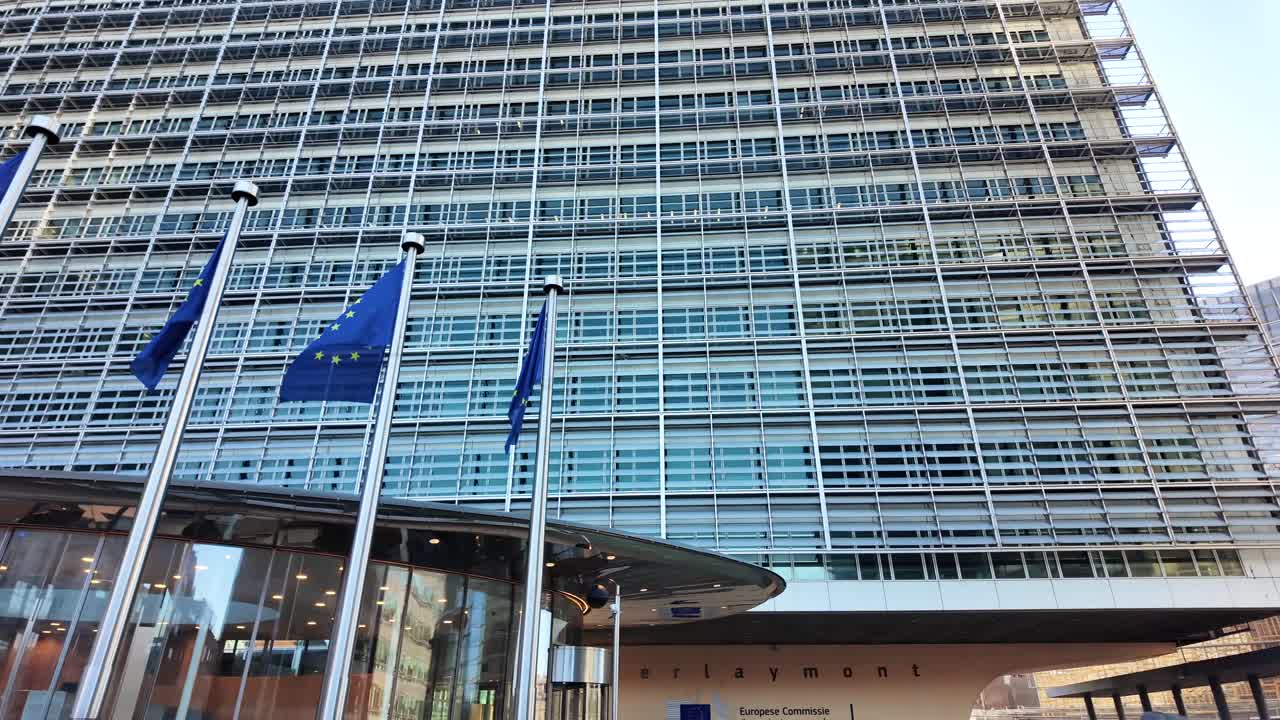 Slow motion of EU flags waving outside European Commission building