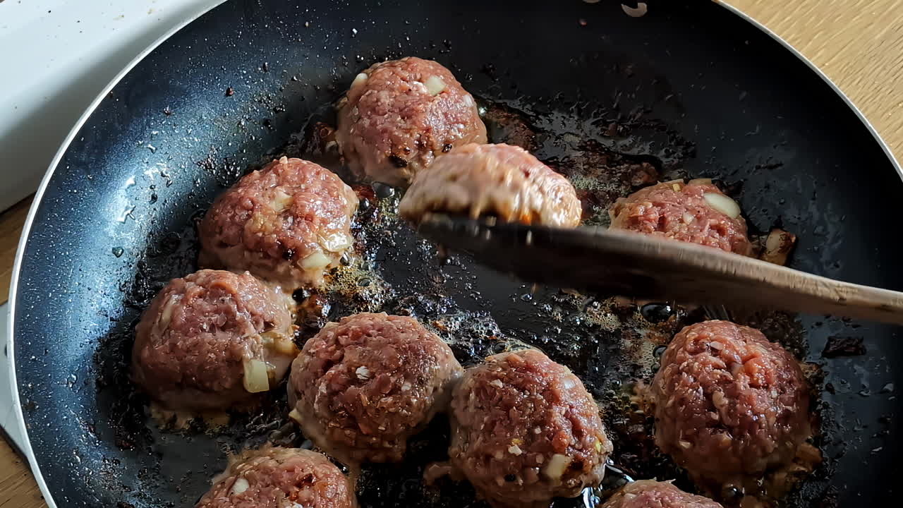 Meat balls are fried in a hot pan in vegetable oil